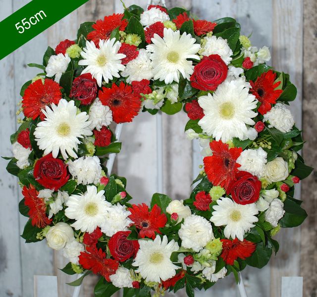 A 55cm floral wreath with white daisies, red roses, and red gerberas, set against a neutral background.